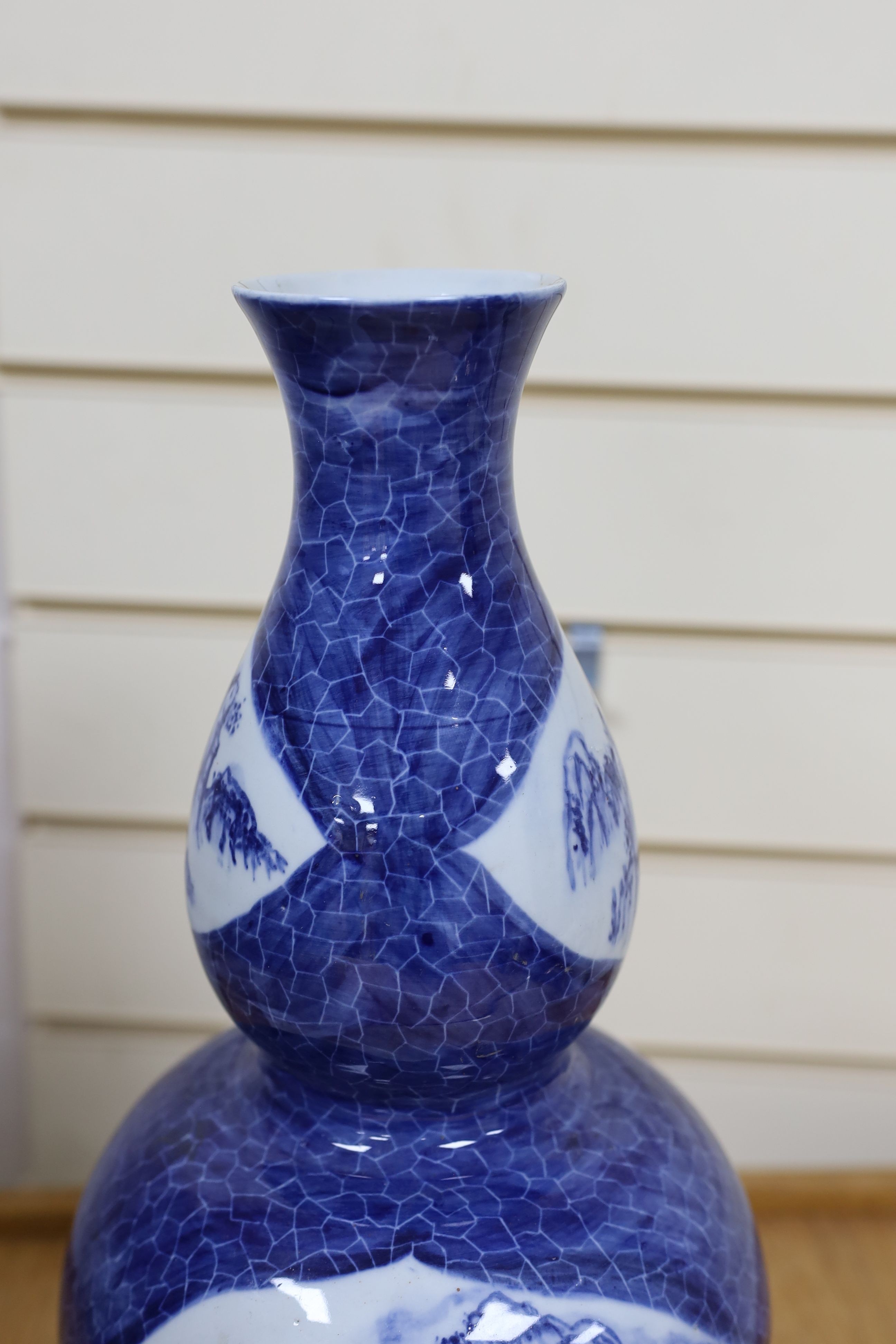 A Chinese blue and white gourd vase with landscape decoration, a similar blue and white sleeve vase and a Japanese Kutani vase